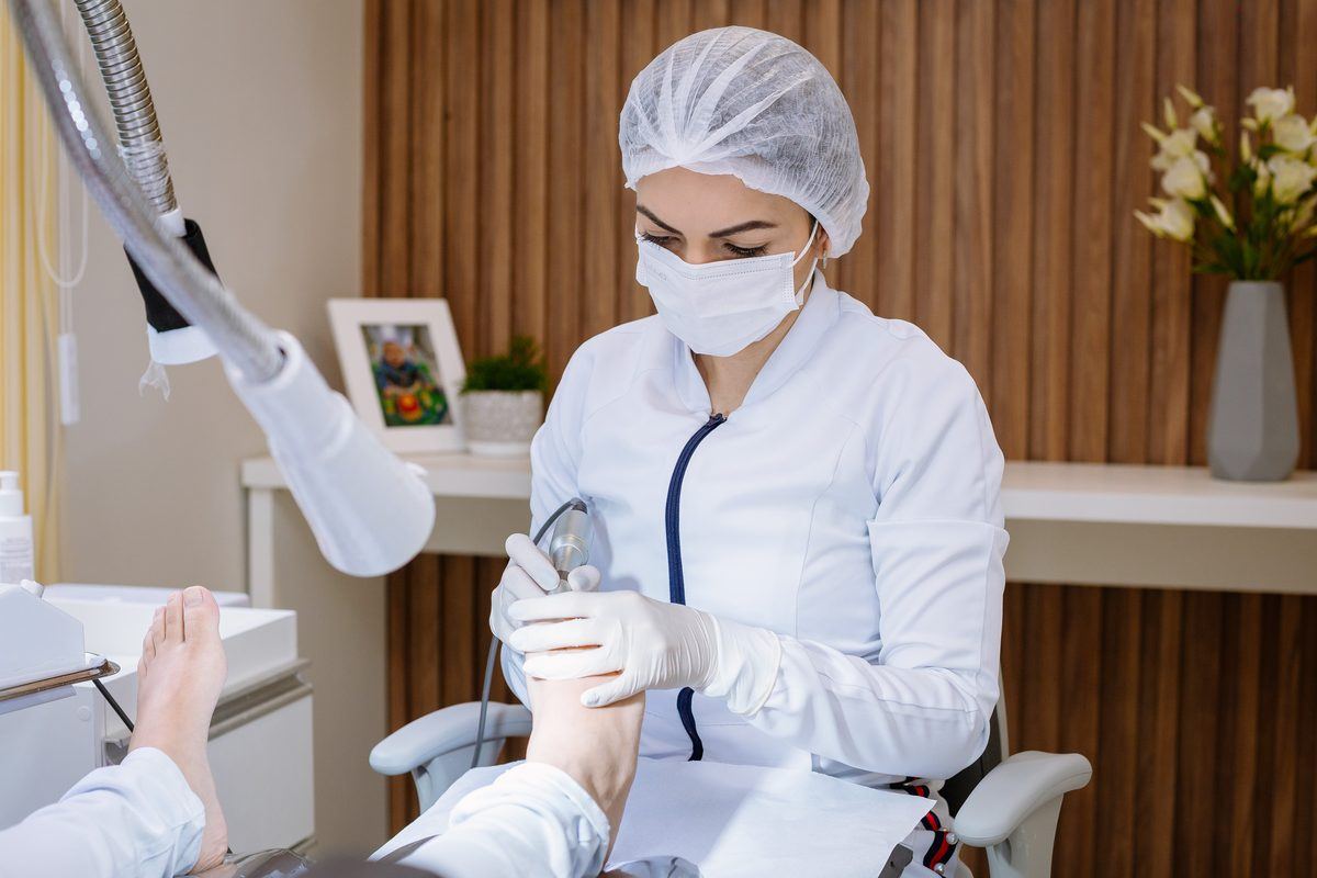 Profissional realizando atendimento em uma clínica real de podologia